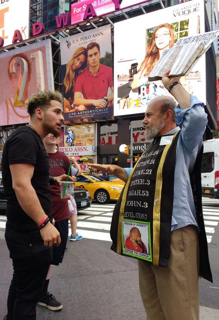 A preacher and passerby argue over religion in Times Square