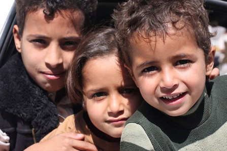 Three children looking interested at the camera