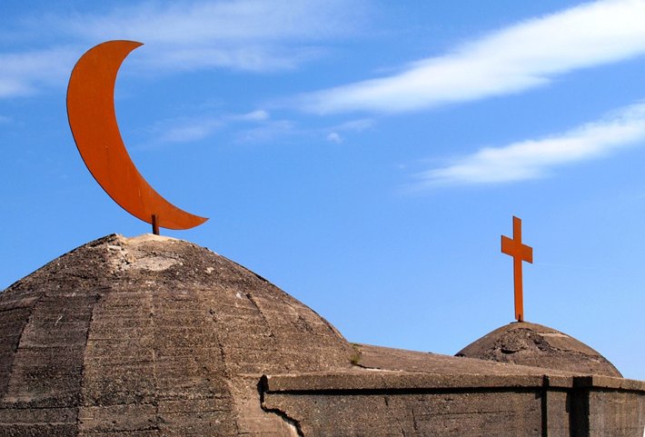 A Muslim symbol and cross atop buildings