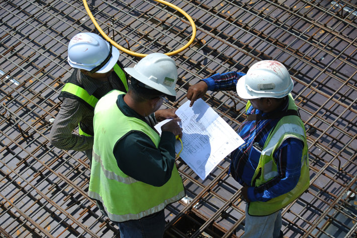 Three men at a construction site