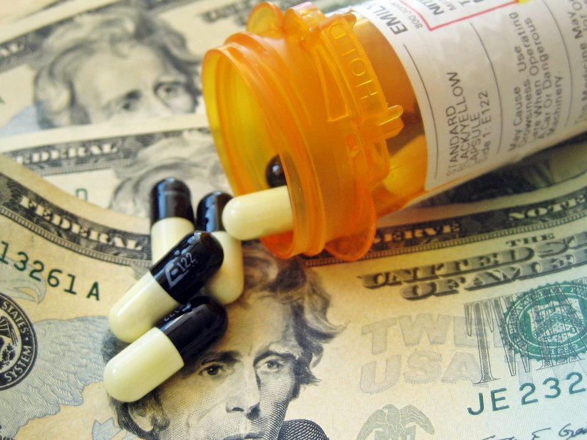 A pill bottle spilling out onto cash