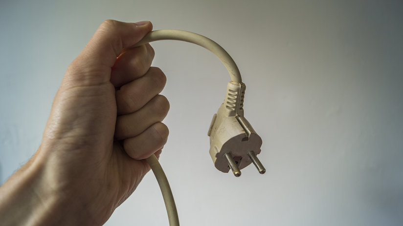 A hand holding a plug