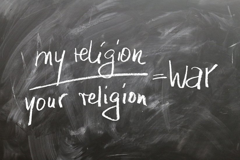 Written on a chalkboard: my religion/your religion=war