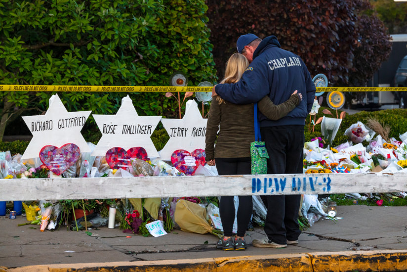 Woman and man in front of temporary memorials