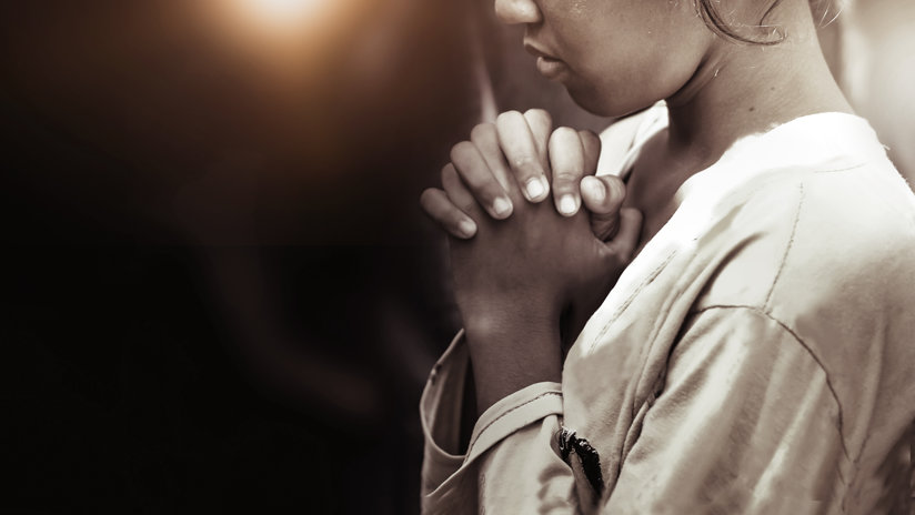 Girl holding her hands in prayer
