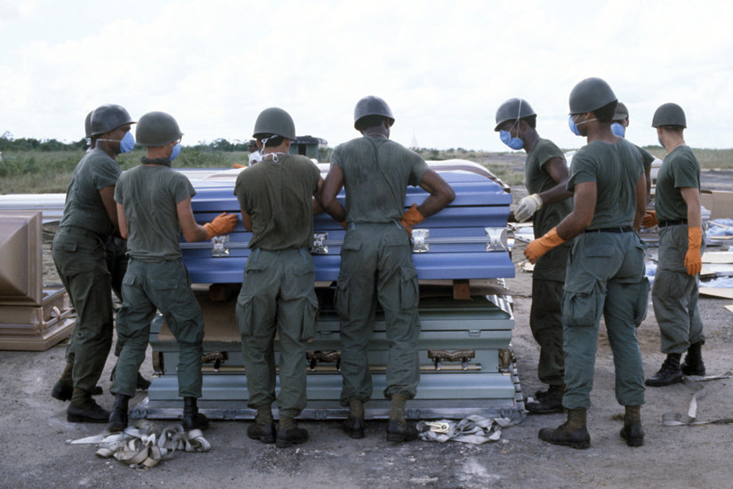 U.S. military personnel stack coffins of victims