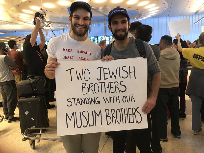 Two Jewish men holding a sign supporting Muslims